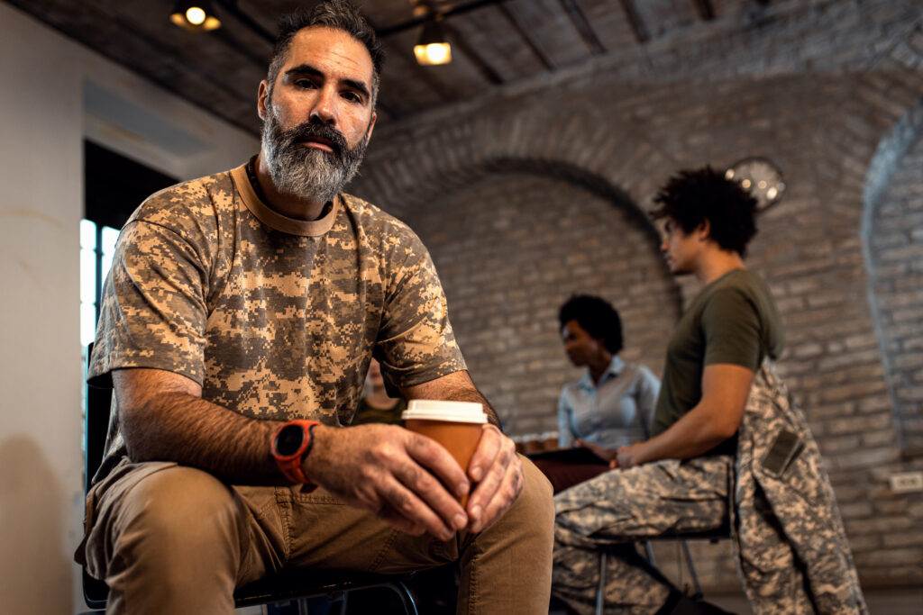 Portrait of male vetaren in PTSD suport goup looking at camera.